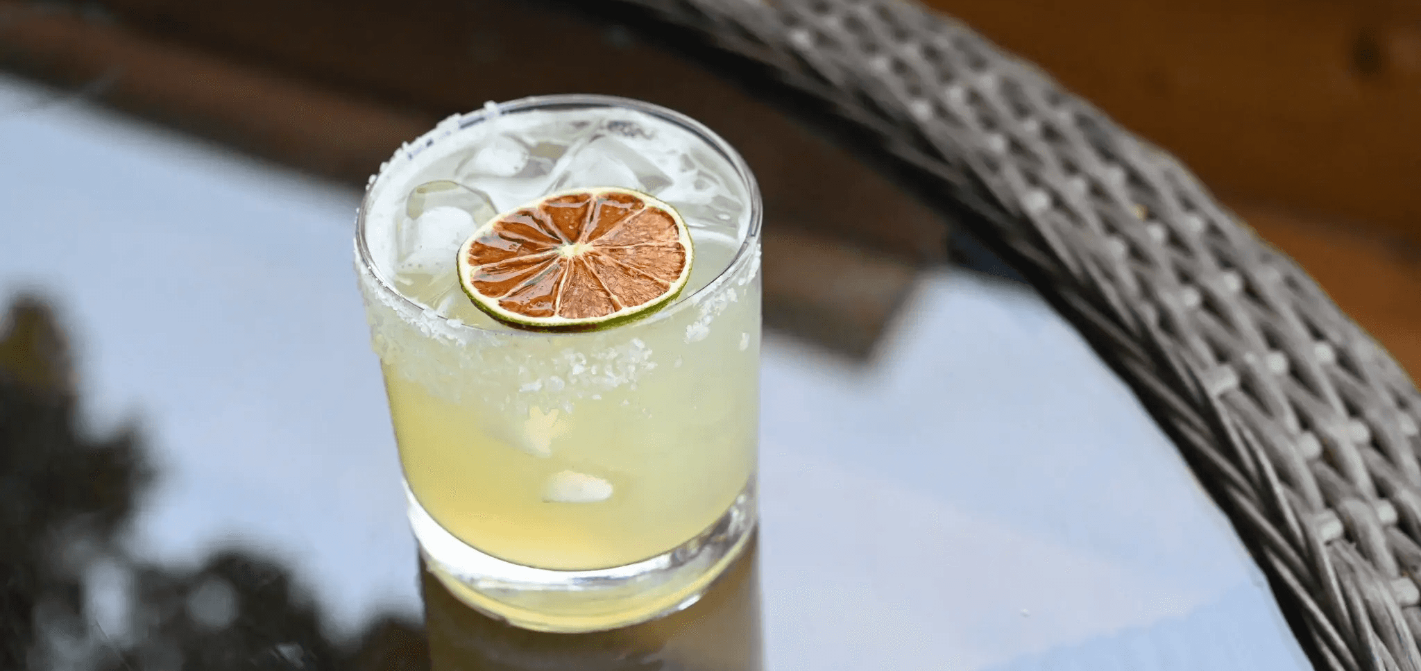 Cocktail with citrus garnish on a dark tabletop