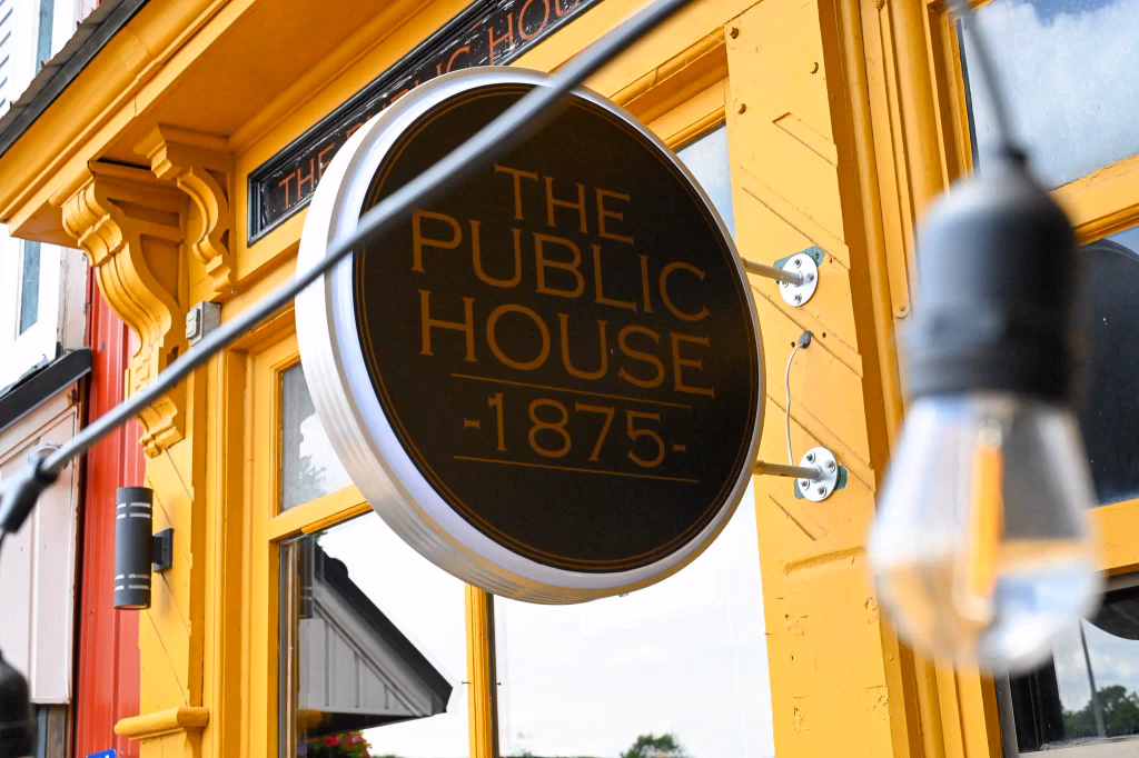 The Public House 1875 exterior sign on a yellow building